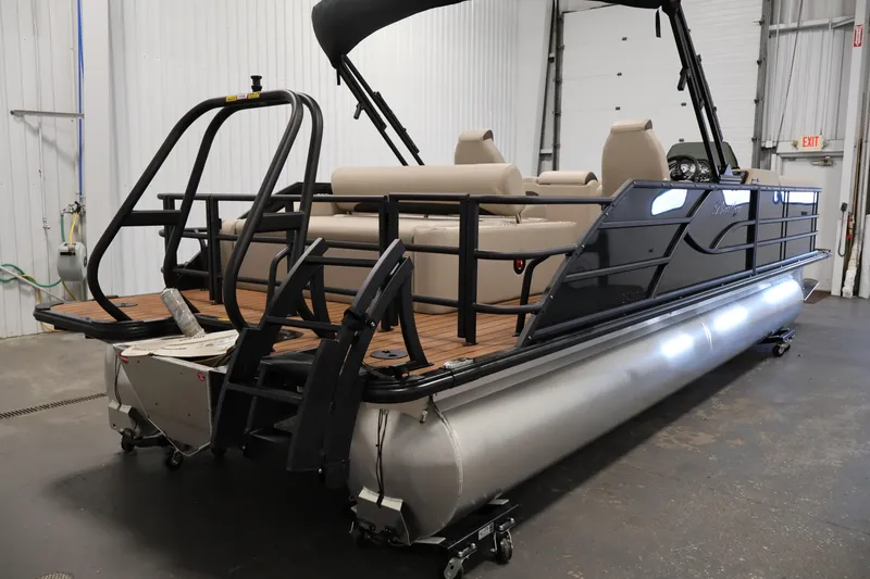 Slide: The Image of 2026 Bentley Pontoons 243 Swingback Tri-toon in a showroom, showcasing sleek design and luxury seating. - 4