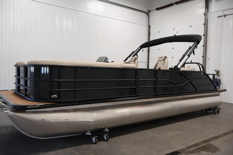 Slide: The Image of 2026 Bentley Pontoons 243 Swingback Tri-toon in showroom, featuring sleek black design and modern seating. - 7