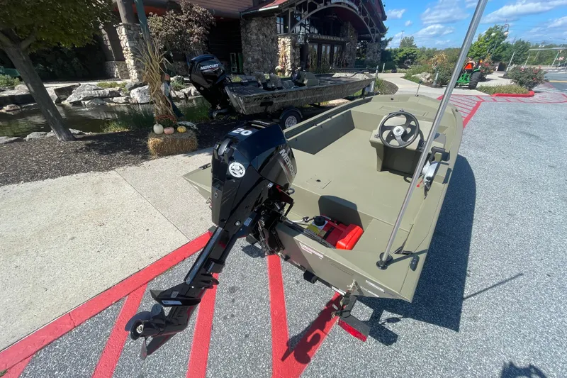 Slide: The Image of 2026 Tracker Grizzly 1648 SC boat with Mercury outboard motor displayed outdoors. - 1