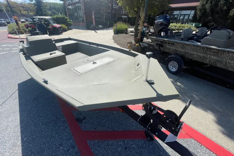 Slide: The Image of 2026 Tracker Grizzly 1648 SC boat on display outdoors, showcasing its sleek design. - 2