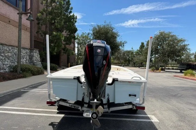 Slide: The Image of 2026 Mako 18 Pro Skiff boat with outboard motor in a parking lot. - 5