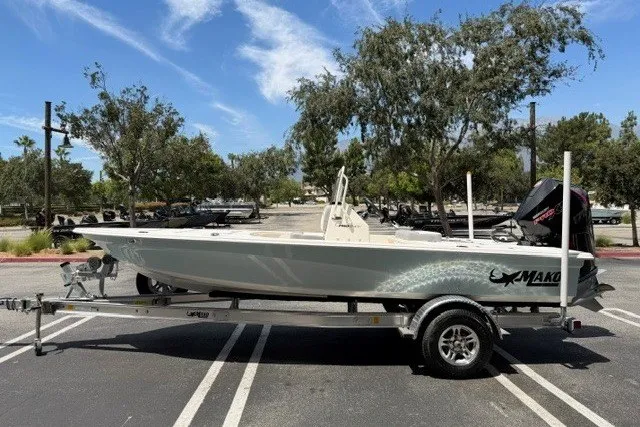 Slide: The Image of 2026 Mako 18 Pro Skiff boat on trailer in sunny parking lot. - 1
