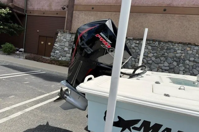 Slide: The Image of 2026 Mako 18 Pro Skiff with powerful outboard motor in a parking lot. - 4