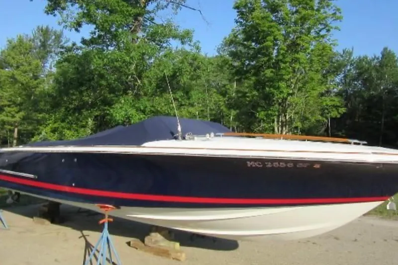 Slide: The Image of 2003 Chris-Craft Corsair 28 boat on stands, surrounded by trees. - 7