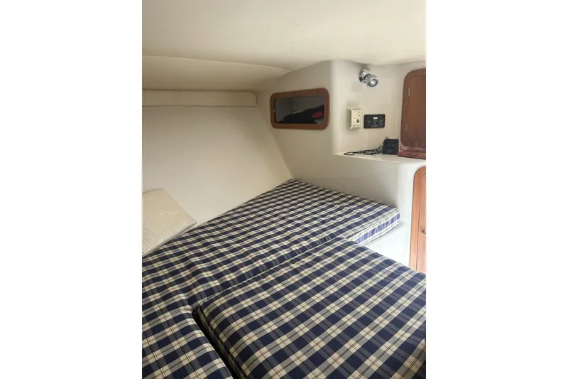 Slide: The Image of 2003 Chris-Craft Corsair 28 cabin interior with plaid bedding and wooden accents. - 8