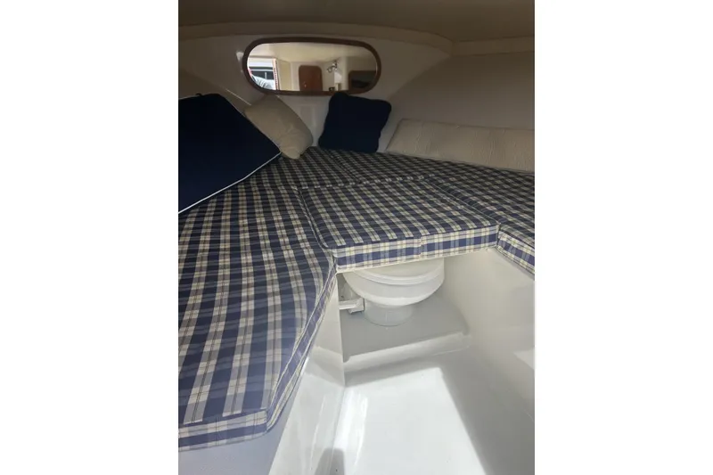 Slide: The Image of Interior cabin of 2003 Chris-Craft Corsair 28 with plaid cushions and compact toilet. - 9