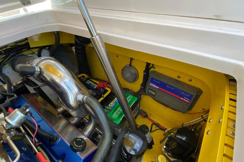 Slide: The Image of Engine compartment of a 2001 Donzi ZX boat, featuring a polished exhaust and battery system. - 14