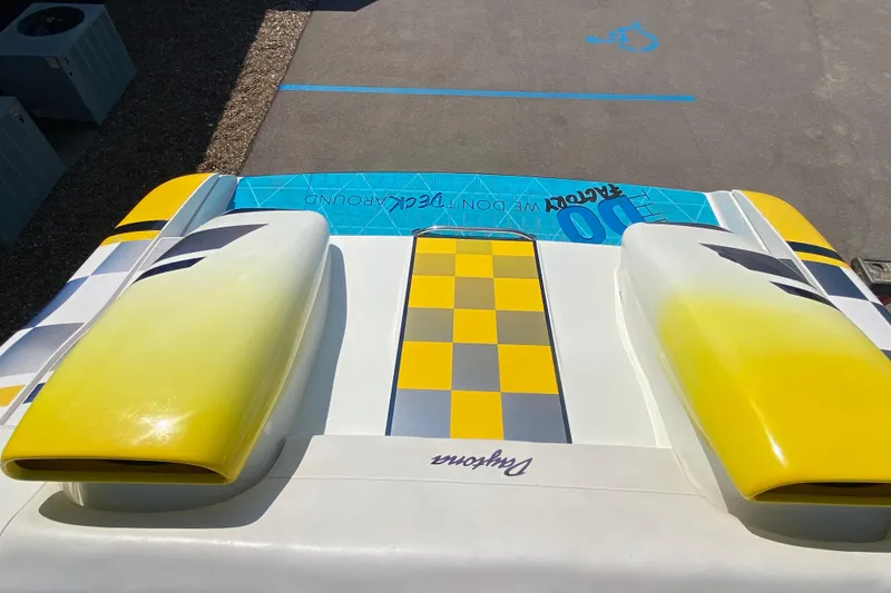 Slide: The Image of 2001 Donzi ZX boat with vibrant yellow and checkered design on deck. - 18