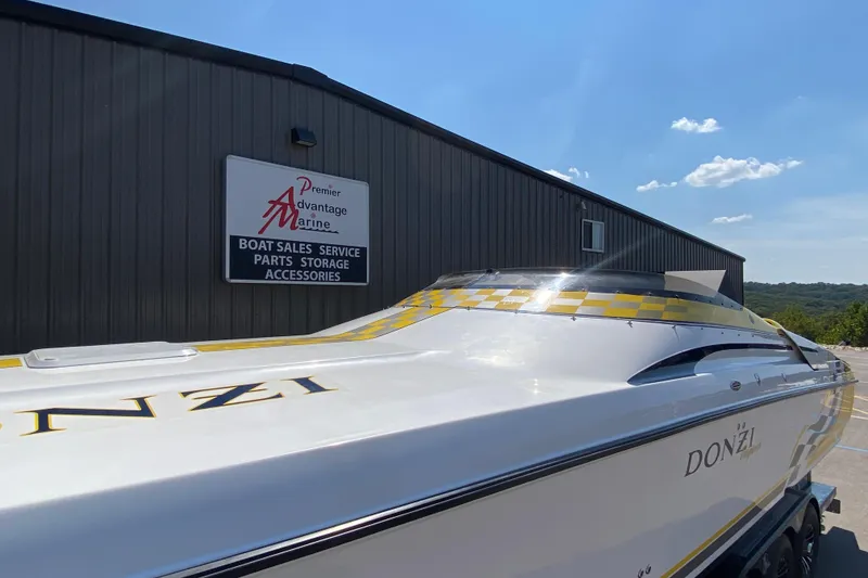 Slide: The Image of 2001 Donzi ZX boat at Premier Advantage Marine dealership under clear blue sky. - 2