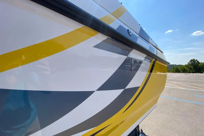 Slide: The Image of 2001 Donzi ZX boat with vibrant yellow and gray graphics under a clear blue sky. - 21