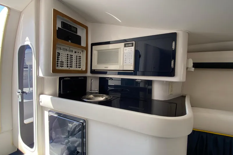 Slide: The Image of 2001 Donzi ZX boat interior with kitchenette, featuring microwave and sink. - 23