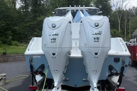 Slide: The Image of 2022 Sea Hunt Gamefish 30 with twin 300 V6 engines, parked outdoors. - 2