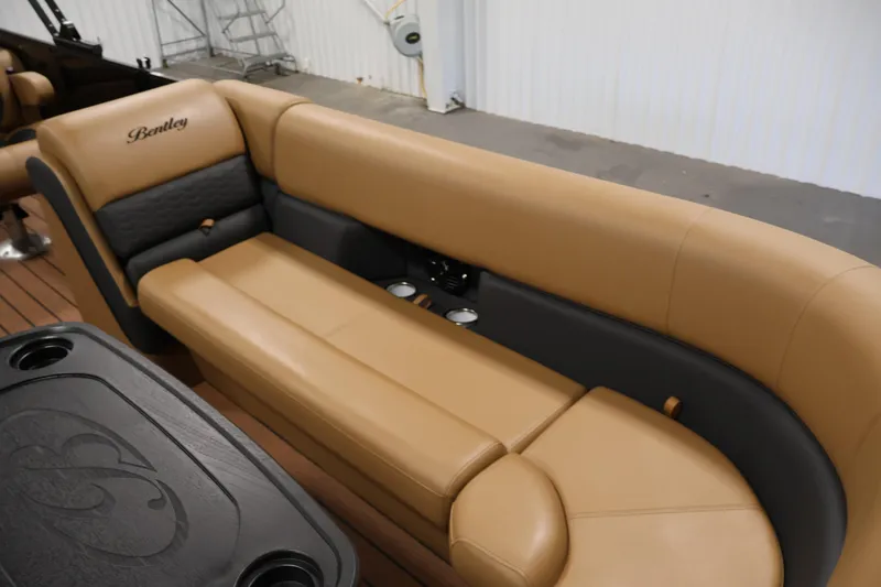 Slide: The Image of 2026 Bentley Pontoons Elite 253 interior with tan seating and storage compartment. - 11