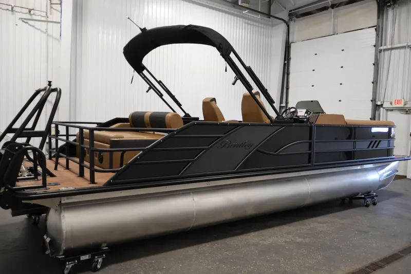 Slide: The Image of 2026 Bentley Pontoons Elite 253 Swingback Tri-Toon with dual captain chairs in a showroom. - 3