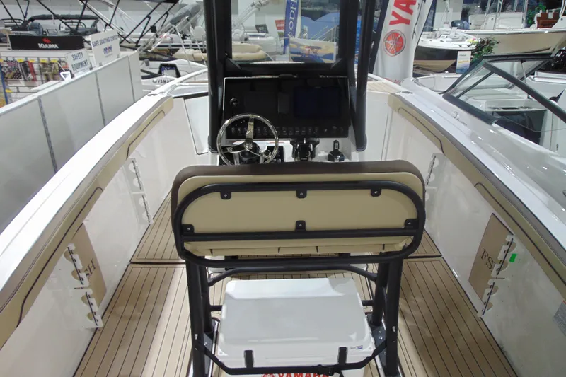 Slide: The Image of 2026 Yamaha Boats 255 FSH Sport H interior with helm and seating, showcased at a boat exhibition. - 10