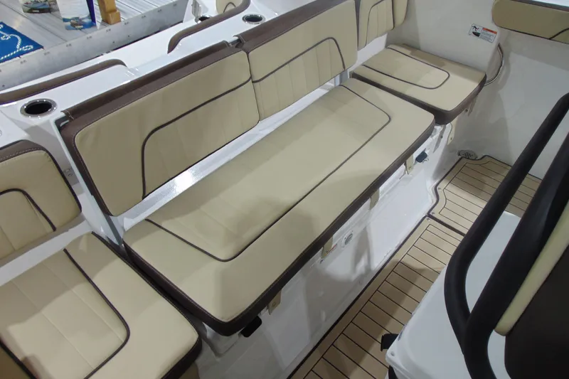 Slide: The Image of 2026 Yamaha Boats 255 FSH Sport H interior seating with beige cushions and cup holders. - 18