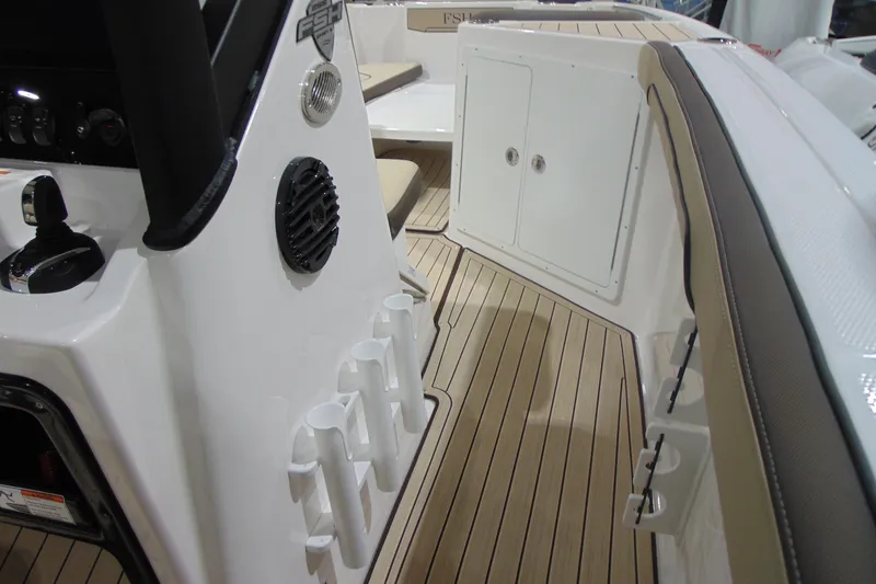 Slide: The Image of 2026 Yamaha Boats 255 FSH Sport H interior with rod holders and teak flooring. - 20