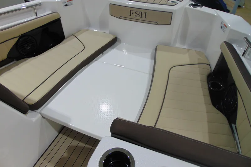 Slide: The Image of 2026 Yamaha Boats 255 FSH Sport H interior seating with beige cushions and cup holders. - 22