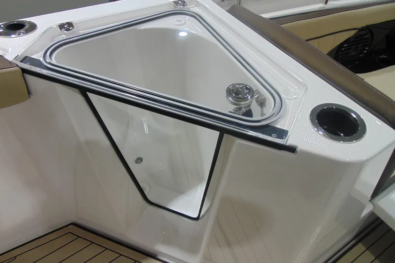 Slide: The Image of 2026 Yamaha Boats 255 FSH Sport H interior with storage compartment and cup holder. - 23