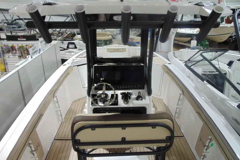Slide: The Image of 2026 Yamaha Boats 255 FSH Sport H interior with steering console and rod holders. - 9