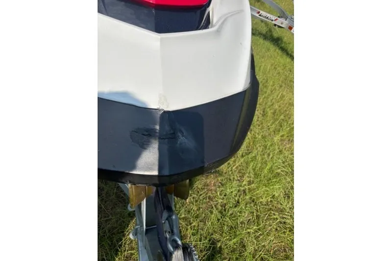 Slide: The Image of 2010 Sea-Doo GTX 155 jet ski with visible hull damage on grass. - 19