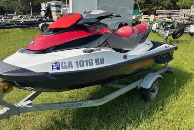 Slide: The Image of 2010 Sea-Doo GTX 155 jet ski on trailer, red and white, parked on grass. - 5
