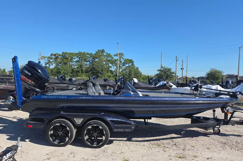 Slide: The Image of 2018 Skeeter FX20 bass boat with Yamaha engine on trailer, parked outdoors. - 1