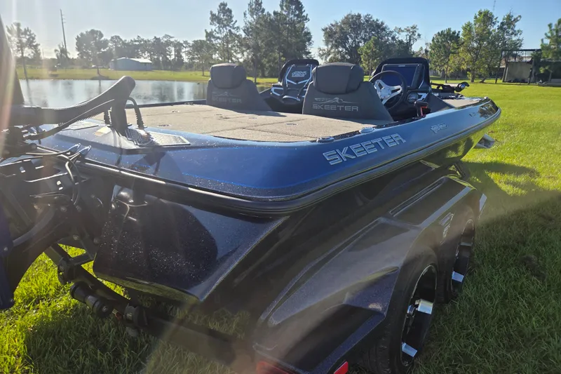 Slide: The Image of 2018 Skeeter FX20 boat on grass near a pond, showcasing sleek design and branding. - 10