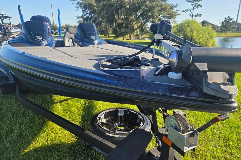 Slide: The Image of 2018 Skeeter FX20 bass boat on trailer, parked on grass near a pond. - 5