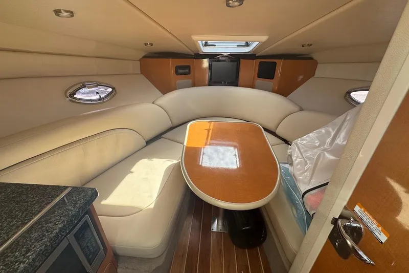 Slide: The Image of Interior of 2010 Chaparral 275 SSi boat with cozy seating and wooden table. - 10