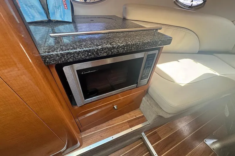 Slide: The Image of 2010 Chaparral 275 SSi interior with microwave, granite countertop, and leather seating. - 11