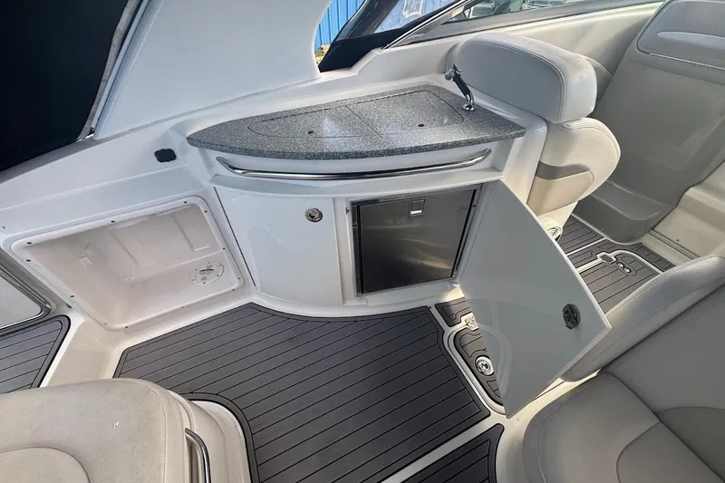 Slide: The Image of 2010 Chaparral 275 SSi boat interior with open cabinet and seating area. - 6