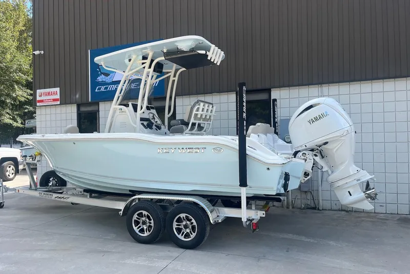 Slide: The Image of 2026 Key West 219 FS boat with Yamaha engine on trailer outside dealership. - 2