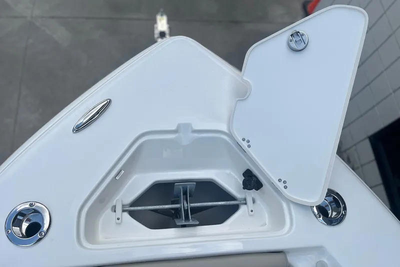 Slide: The Image of 2026 Key West 219 FS boat anchor compartment with open hatch, showcasing sleek design. - 24
