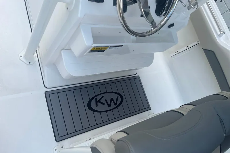 Slide: The Image of 2026 Key West 219 FS boat interior with steering wheel and branded floor mat. - 6