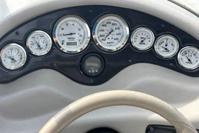 Slide: The Image of Dashboard of a 2005 Stingray 220 DR boat with gauges and steering wheel. - 12