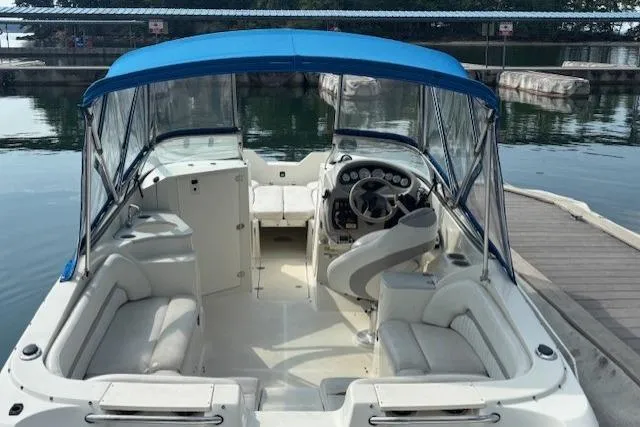 Slide: The Image of 2005 Stingray 220 DR boat with blue canopy, docked at marina. - 4