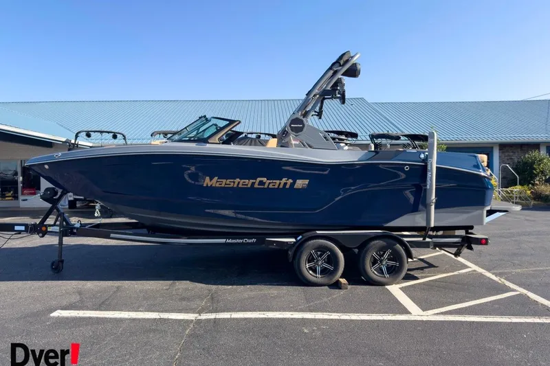 The Image of 2026 MasterCraft XT22 boat on trailer, parked outdoors, side view. - 1