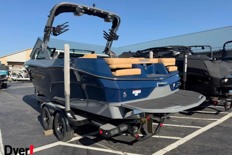 Slide: The Image of 2026 MasterCraft XT22 boat with blue exterior and tan seating on a trailer. - 2