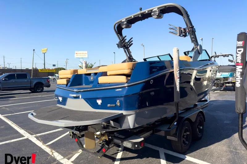 Slide: The Image of 2026 MasterCraft XT22 boat in parking lot, blue exterior, tan seats, on trailer. - 4