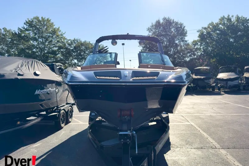 Slide: The Image of 2026 MasterCraft XT22 boat in a sunny outdoor showroom, front view. - 6