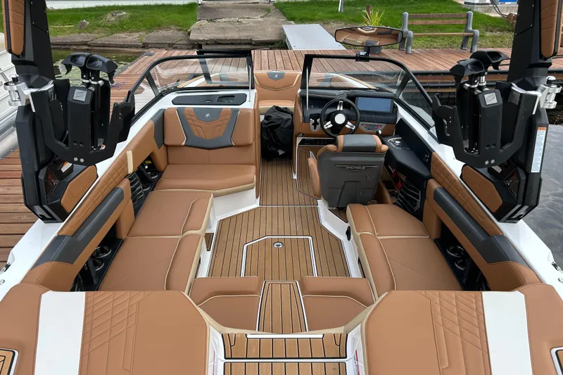 Slide: The Image of 2022 Nautique Super Air Nautique G21 interior with tan seating and modern dashboard. - 3