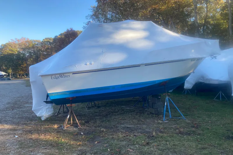Slide: The Image of 1999 Edgewater 220CC boat covered and stored outdoors on stands. - 7