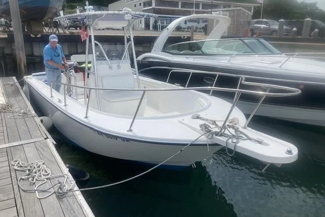 Slide: The Image of 1999 Edgewater 220CC boat docked at marina with person onboard. - 4