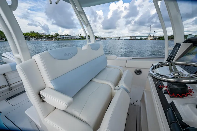 Slide: The Image of 2023 Robalo R302 Center Console boat interior with helm and seating, overlooking waterway. - 10