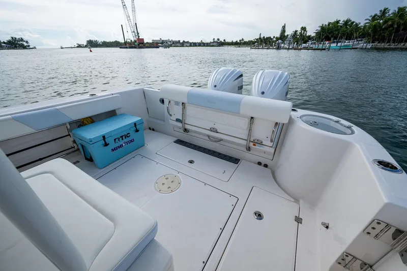 Slide: The Image of 2023 Robalo R302 Center Console boat with RTIC cooler on deck, docked by the water. - 13