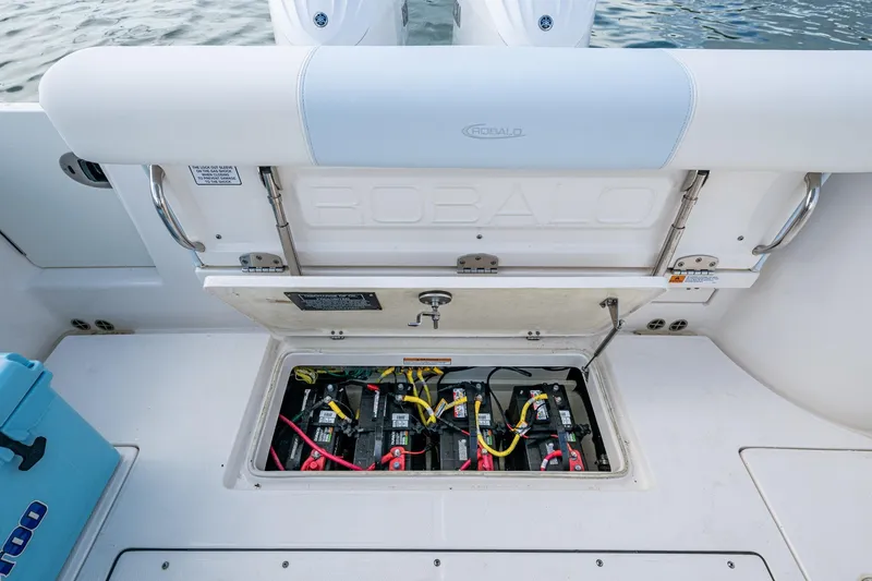 Slide: The Image of 2023 Robalo R302 Center Console boat battery compartment open, showing wiring and connections. - 15