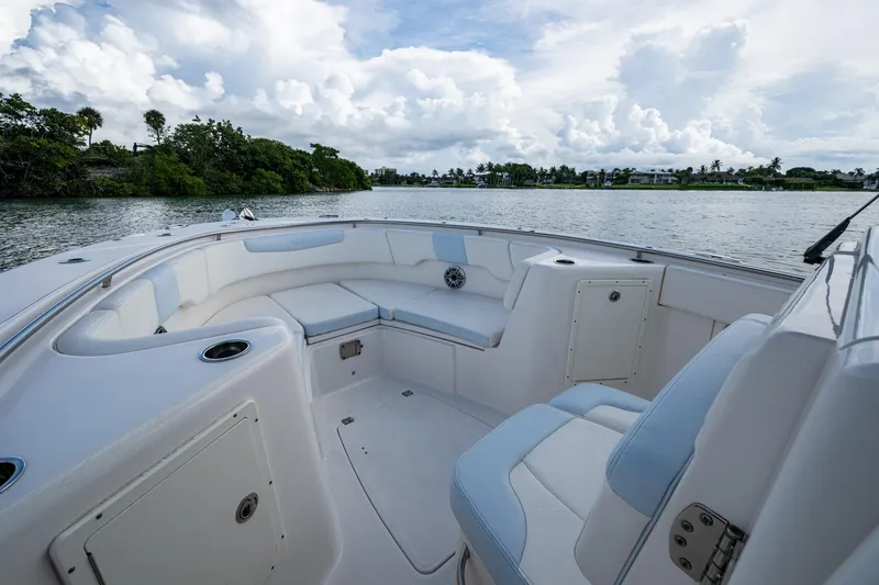 Slide: The Image of 2023 Robalo R302 Center Console boat interior with cushioned seating, on a scenic waterway. - 3