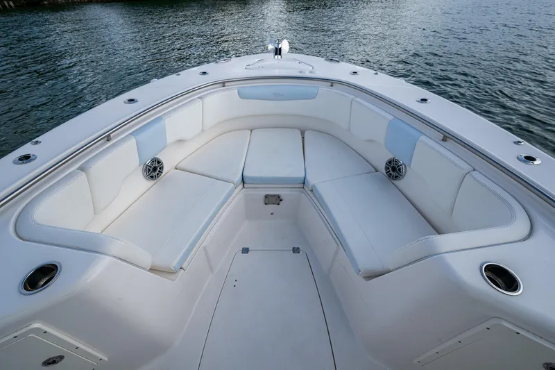 Slide: The Image of 2023 Robalo R302 Center Console boat with spacious seating and cup holders on calm water. - 4