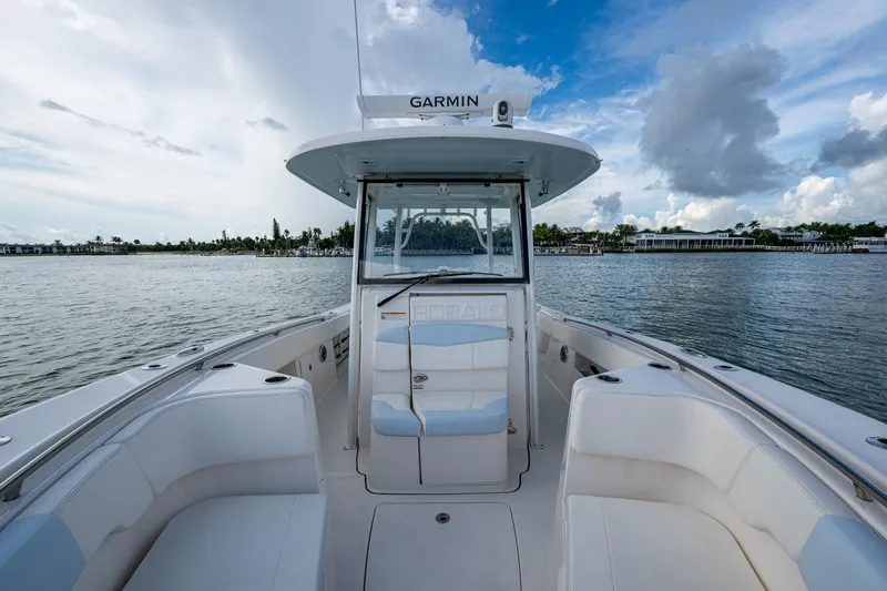 Slide: The Image of 2023 Robalo R302 Center Console boat on calm water under a partly cloudy sky. - 6
